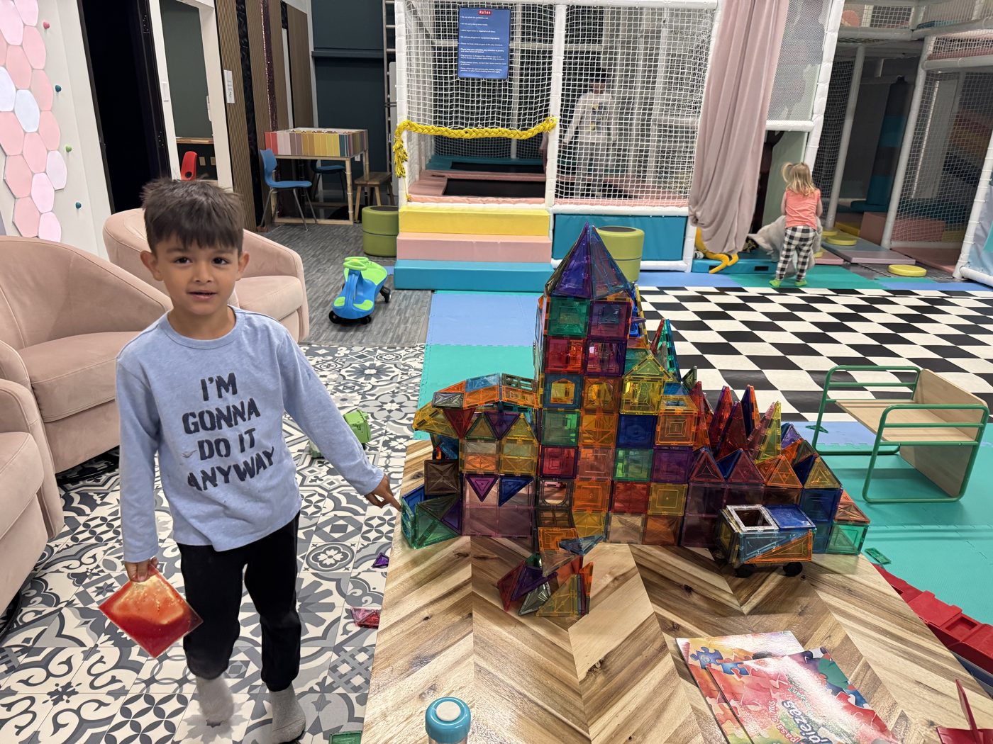 A child building a tower of magnetic tiles at Prana Play